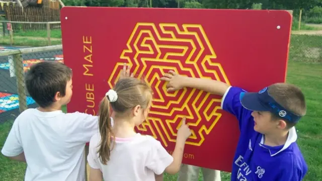 متاهة الإصبع وأطفال يحاولون المرور بأصابعهم من خلالها