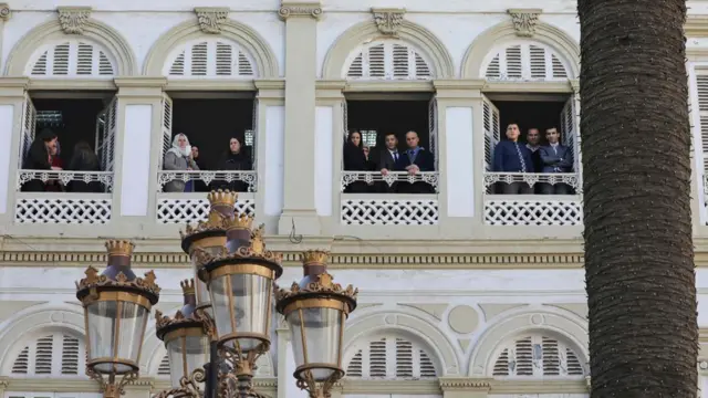 Guyyaadhuma kana lammiileen Aljeeriyaa, Magaalaa Aljiyers keessa jiraatan, pireezidaantii Faransaay daawwachuuf foddaa irraa gadi ilaalaa turan...
