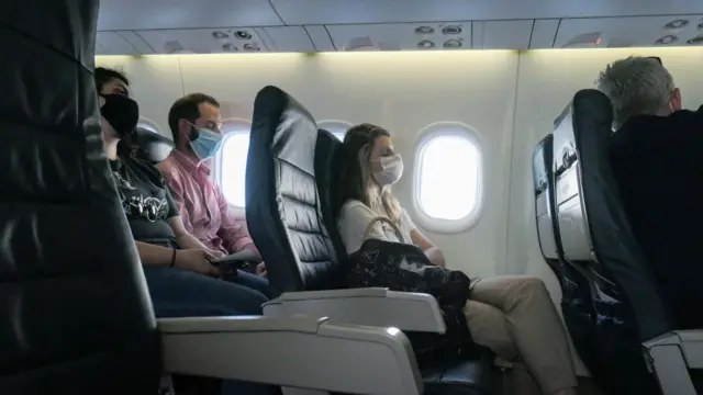 Pasajeros con mascarilla en un avión