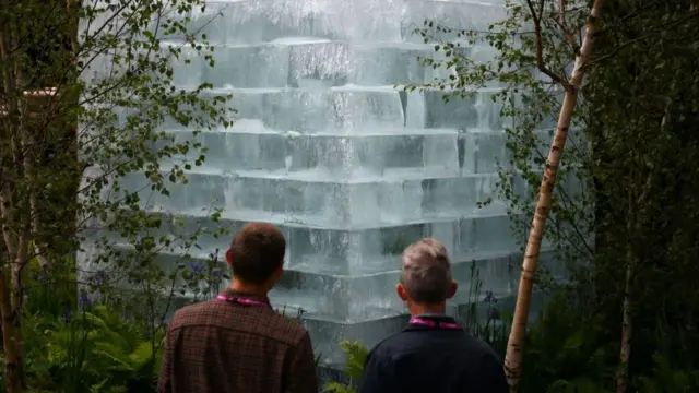 Visitors look at stacked blocks of ice in 'The Plantman's Ice Garden' at the Sanctuary Garden at the 2022 RHS Chelsea Flower Show in London on May 23, 2022.