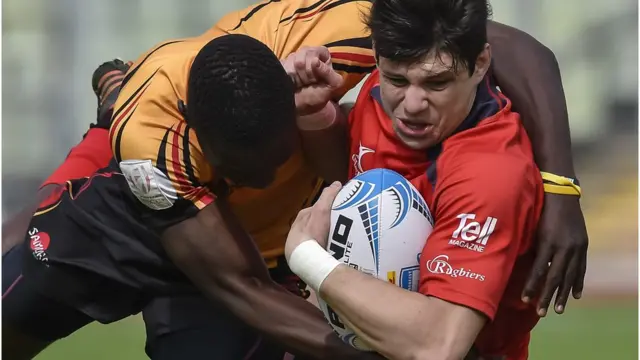 Uganda rugby player dey tackle Chile player