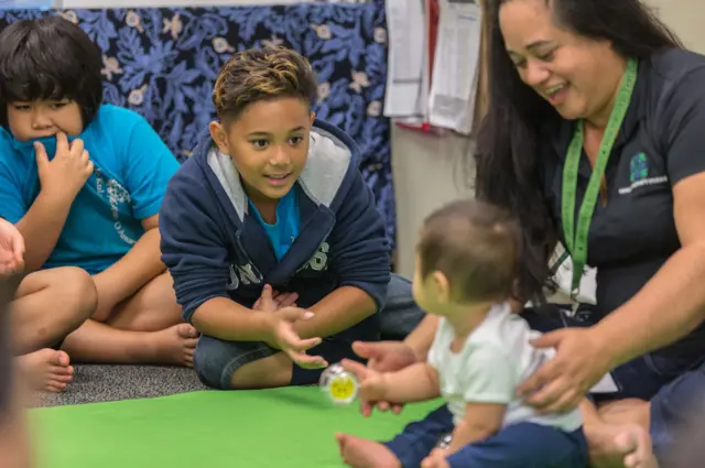 Niños interactúan con un bebé durante el programa.