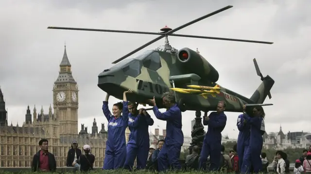Campaigners carry a model of a Chinese Z-10 attack helicopter near the Houses of Parliament on October 2, 2006 in London. A coalition of charities are calling for the closing of loopholes in arms export regulations to stop sales of weapons to countries that are under arms embargoes and have bad human rights records.
