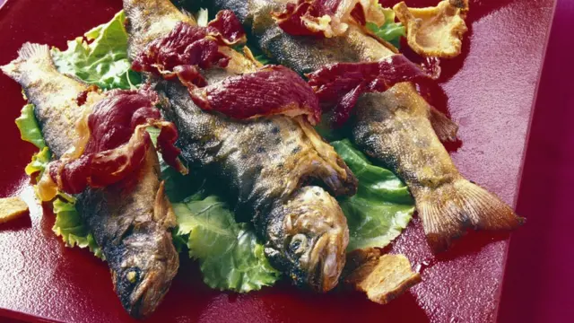 Форель с беконом на красном блюде