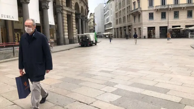 Pedestre com máscara em Milão