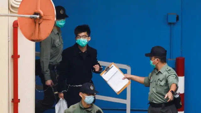 FILE PHOTO: Pro-democracy activist Joshua Wong walks to a prison van to head to court with other activists, over a national security law charge, in Hong Kong, China March 4, 2021. REUTERS/Tyrone Siu/File Photo