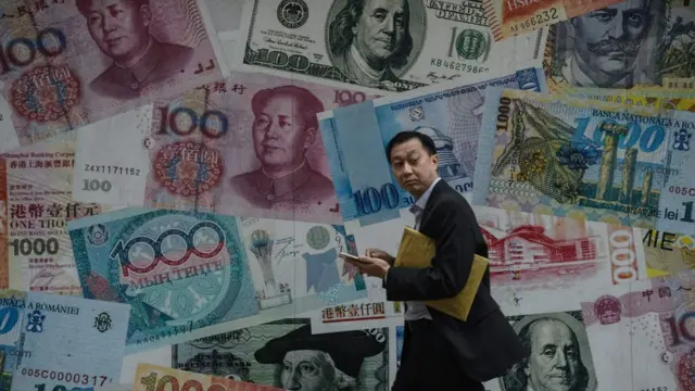 Hombre camina frente a un mural de billetes