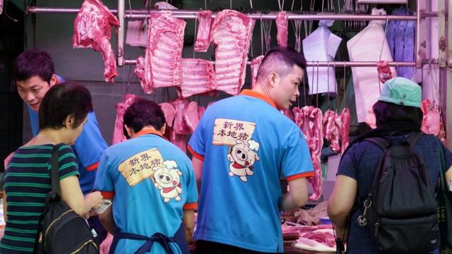 香港湾仔一家肉店店员穿上“新界本地猪”制服招揽顾客（中新社图片11/5/2019）