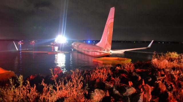 一架波音737包机在黑夜和雷雨中在美国佛罗里达州降落失败后冲出跑道，最终滑入一条河里。