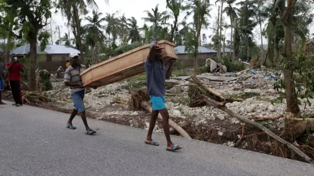 Fotoğrafta tabut taşıyan Haitililer görülüyor.