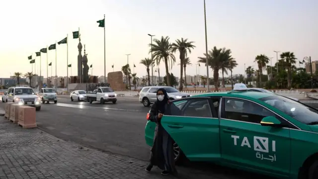 A woman getting out of a taxi in Jeddah, Saudi Arabia