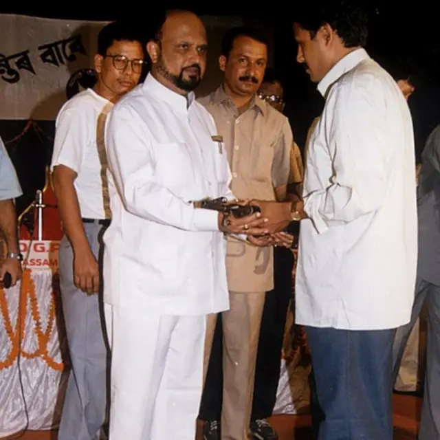 আসামের মুখ্যমন্ত্রী প্রফুল্ল মহন্তর কাছে অস্ত্র সমর্পণ করছেন আলফার একজন সদস্য।