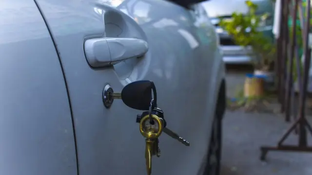 Una puerta de un auto con las llaves puestas.