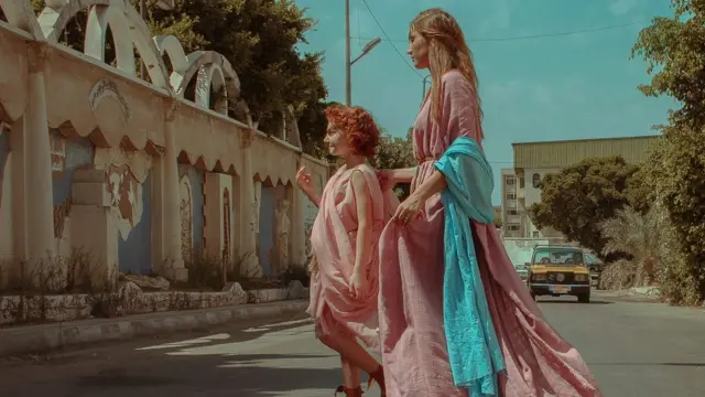 شابة وفتاة صغيرة ترتديات الزي الروماني وتسيران في أحد شوارع الاسكندرية