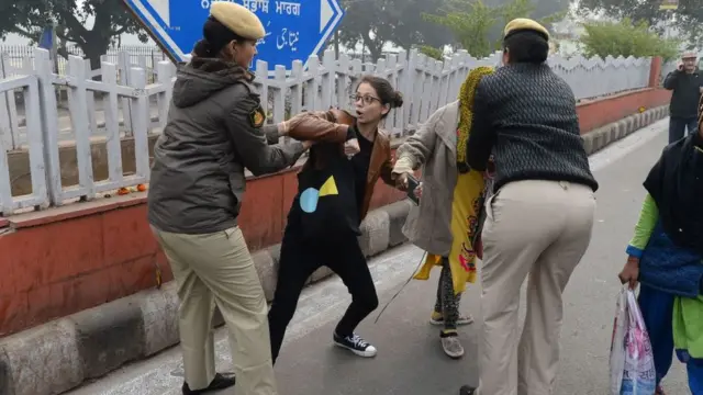 પ્રદર્શનકારી યુવતી અને પોલીસ