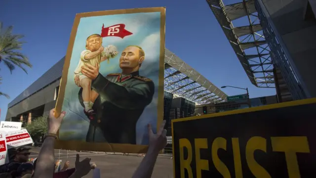 Плакат с Путиным в военном мундире, держащим на руках младенца-Трампа