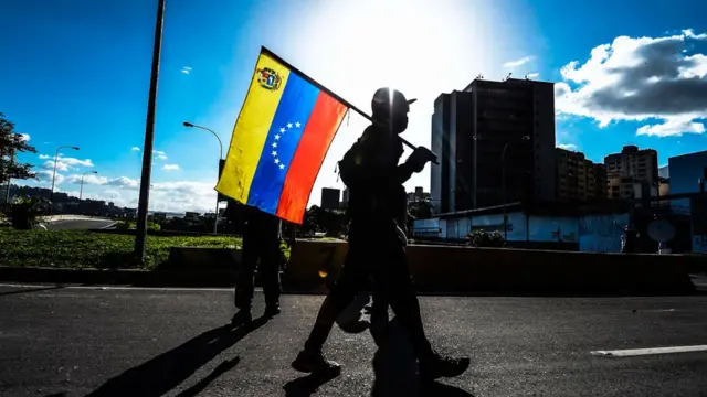 Pessoa segurando a bandeira da Venezuela