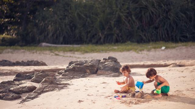 Duas crianças brincando na praia