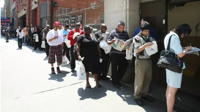 Personas en busca de empleo hacen cola en Nueva York.