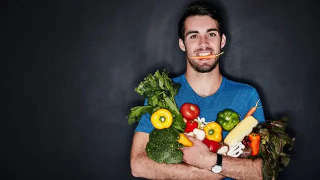 Homem carrega verduras e legumes