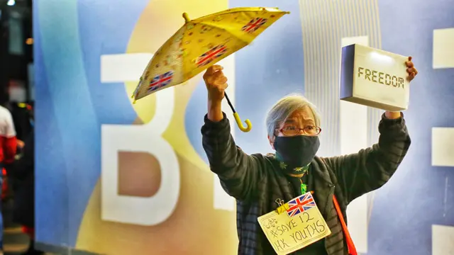 王婆婆在尖沙咀天星小輪碼頭對面高舉黃傘，高呼「聖誕快樂」、「五大訴求，缺一不可」、「願榮光歸香港」等口號。