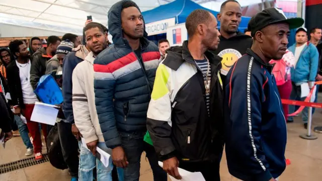 Haitianos hacen fila para regularizar sus papeles.