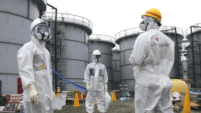 東京電力公司人員身穿防護衣帶領記者視察福島第一核電站殘骸（7/11/2013）