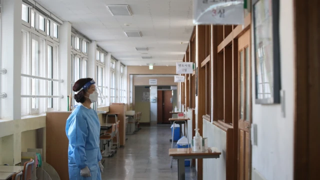 방호복을 입은 감독관이 수능을 앞두고 시험장 점검을 하고 있다