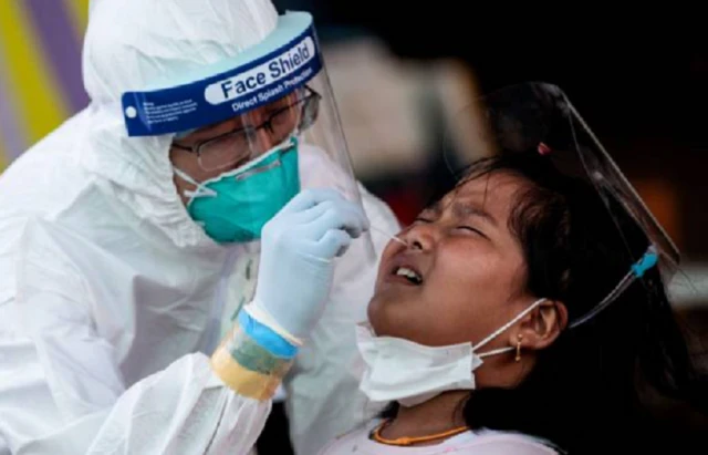 Medical officials conduct a nose swab test on a girl for the COVID-19 coronavirus at a seafood market in Samut Sakhon on December 19, 2020 after some new cases of local infections were detected and linked to a vendor at the market.