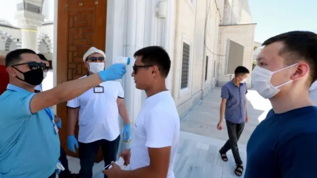 Проверка температуры на входе в мечеть в Бишкеке