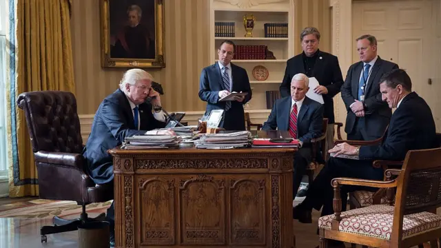 Donald Trump con su equipo de trabajo habla por teléfono en la Oficina Oval.