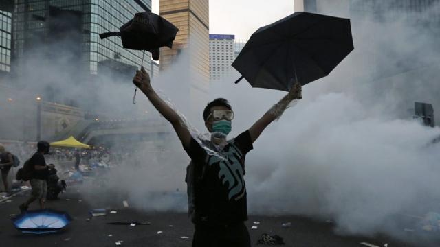 A protester raises an umbrella during demonstrations outside the government headquarters in Hong Kong, 28 September 2014
