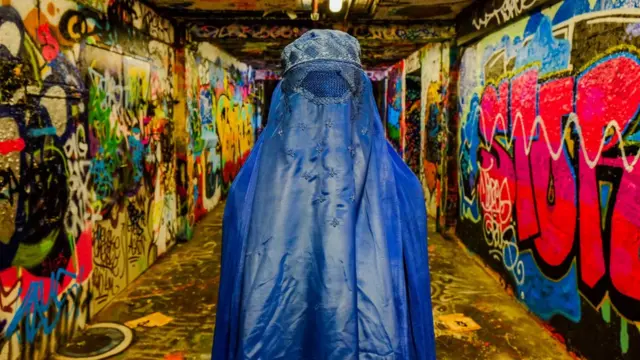 Grafittiler arasında burkalı bir kişi