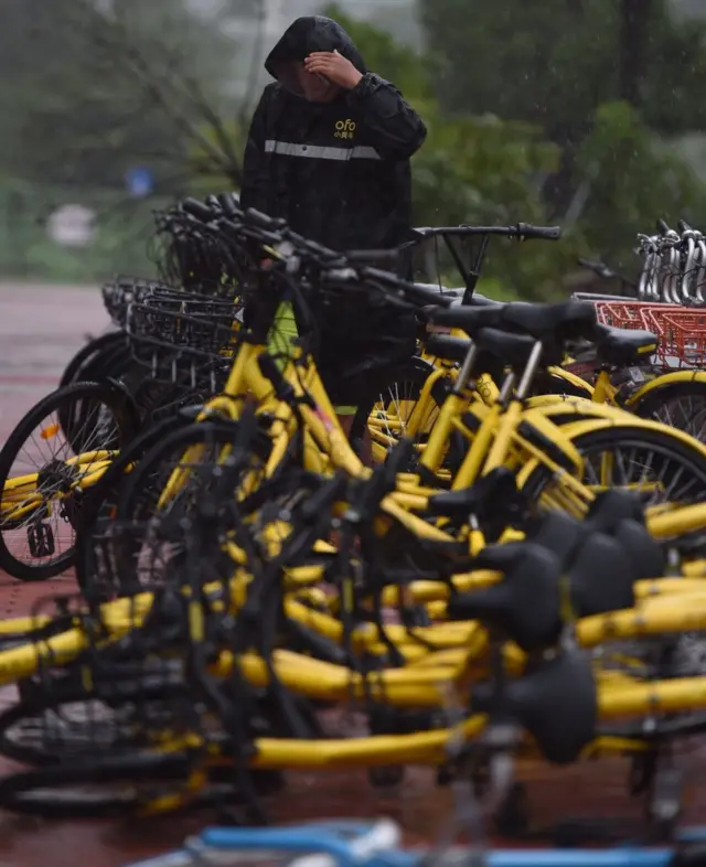 深圳街頭一名共享單車運維人員冒著颱風整理自行車（新華社圖片27/8/2017）