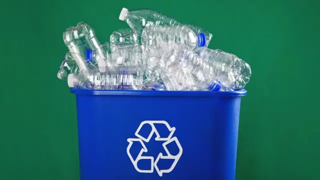 Basurero lleno de botellas de plástico