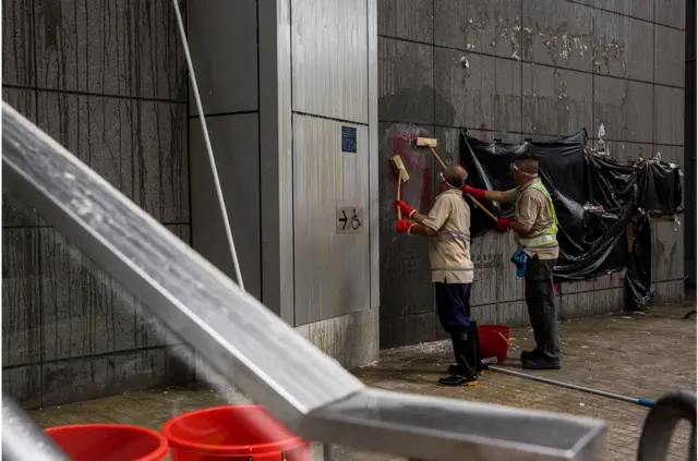 香港警察总部周五晚被大批示威者包围,外墙墙面被示威者投掷鸡蛋,警方早上派人清理。