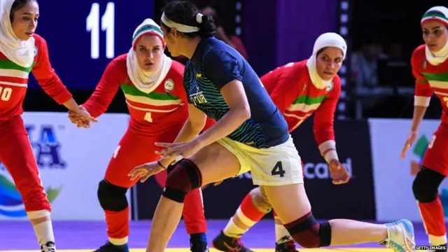 India's Randeep Kaur Khehra (C) tries to score as Iran's players defend during the women's team kabaddi finals match between India and Iran at the 2018 Asian Games in Jakarta