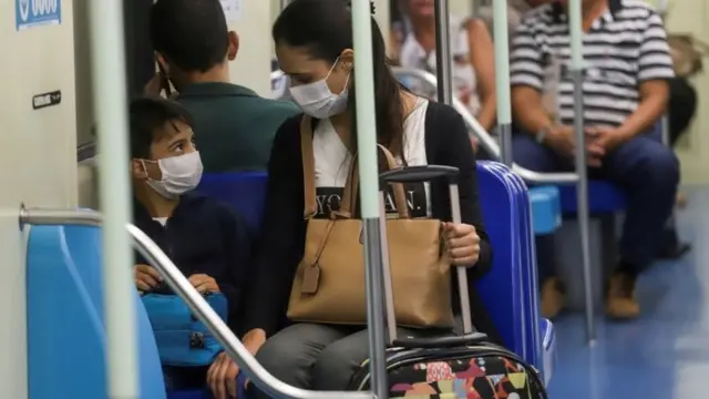 Pessoas usando máscaras no metrô