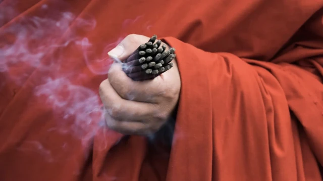 incense in a Buddhist monk's hand