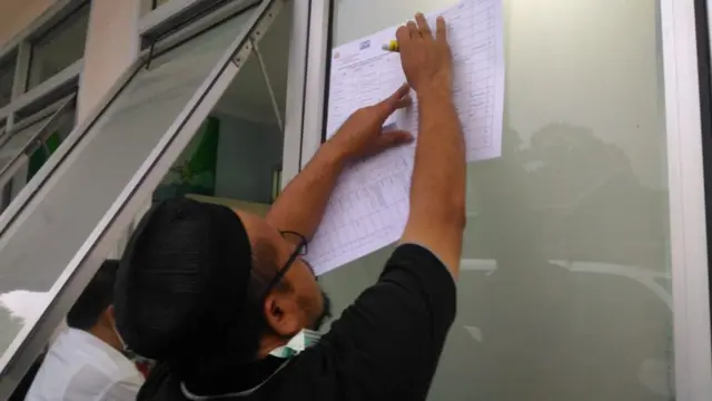 Anggota Tim DVI menempelka daftar jenazah korban tsunami yang sudah teridentifikasi di RS Berkah, Pandeglang (24/12).