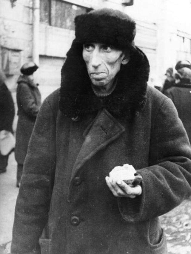 Житель блокадного Ленинграда с выданной дневной нормой хлеба