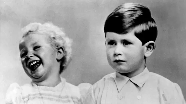 Princess Anne laughing while she is posing with her brother Prince Charles