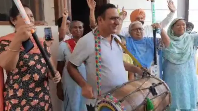 ਮਨਦੀਪ ਦੇ ਪਿਤਾ ਰਵਿੰਦਰ ਸਿੰਘ ਗਲੇ ਚ ਢੋਲ ਪਾ ਕੇ ਮਨਪ੍ਰੀਤ ਸਿੰਘ ਦੇ ਪਰਿਵਾਰ ਵਾਲਿਆਂ ਨਾਲ ਖੁਸ਼ੀ ਸਾਂਝੀ ਕਰਦੇ ਹੋਏ