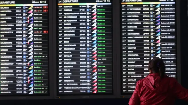 Пассажир перед табло во время кризиса с "ВИМ-Авиа"