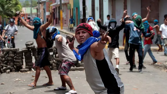Manifestantes lanzando piedras.