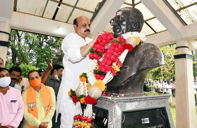 कर्नाटक के नए मुख्यमंत्री बासवराज बोम्मई अपने पिता और पूर्व मुख्यमंत्री एसआर बोम्मई की प्रतिमा पर माल्यार्पण करते हुए