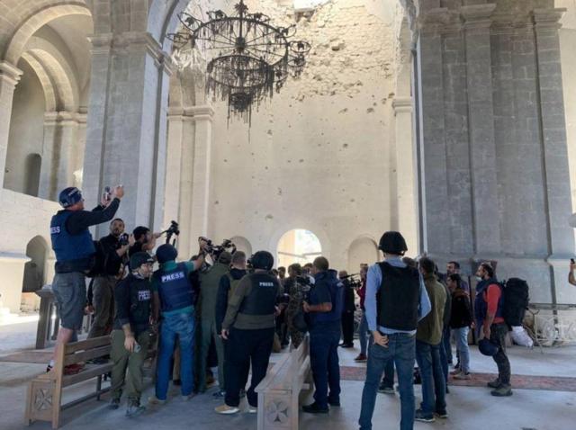 纳戈尔诺—卡拉巴赫地区舒沙市记者争相拍摄一对新人在满布弹痕的教堂废墟内行礼结婚（26/10/2020）