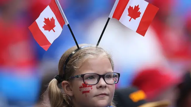 Una niña con banderas de Canadá.