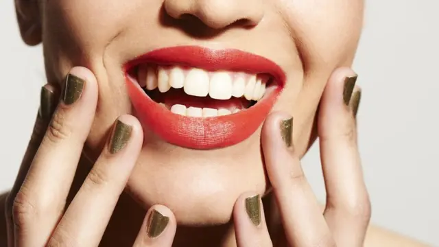 O sorriso de uma mulher em primeiro plano.