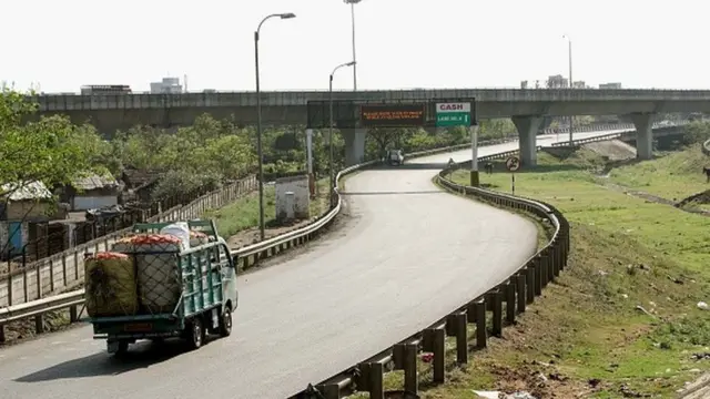 காலியாக கிடக்கும் சாலையில் சந்தைக்கு செல்லும் விவசாய விளைபொருள் ஏற்றிய வண்டி ஒன்று.